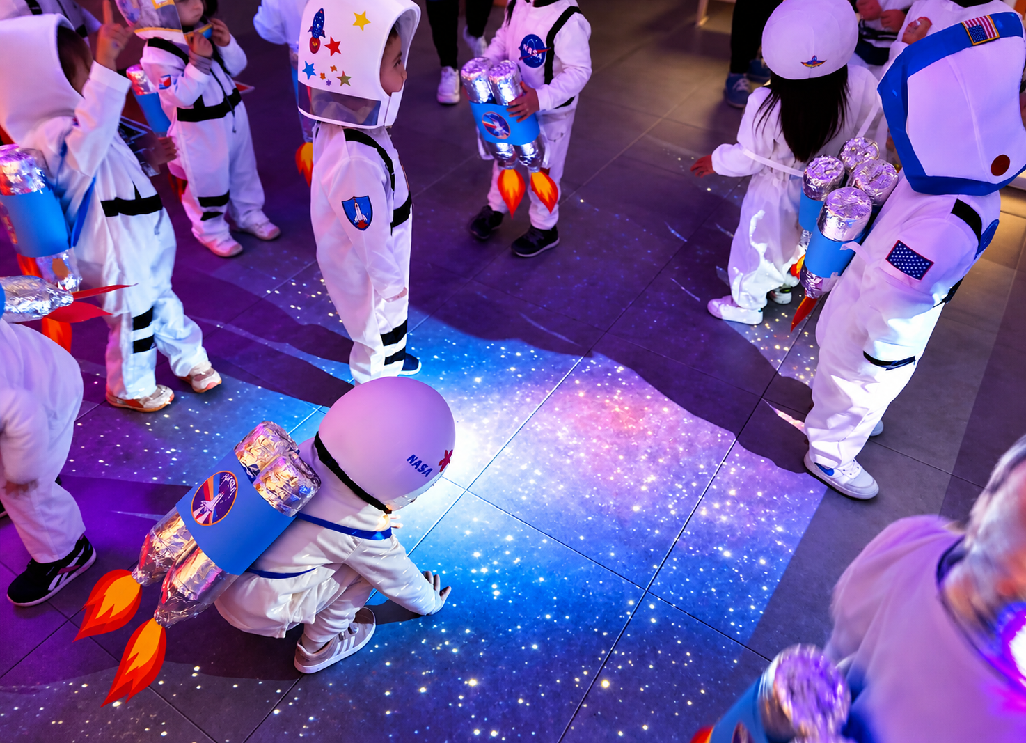 Peques vestidos de astronautas en una actividad con proyecciones del espacio